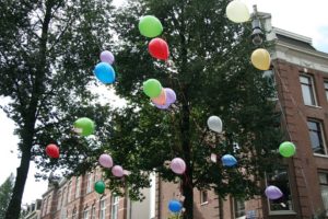 Balloons floating outside of a building.